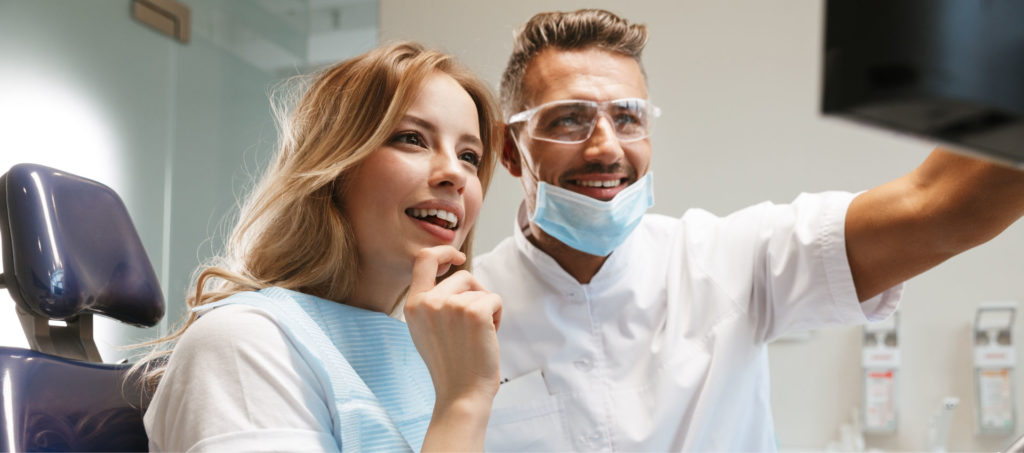 Dentist and patient looking at screen together