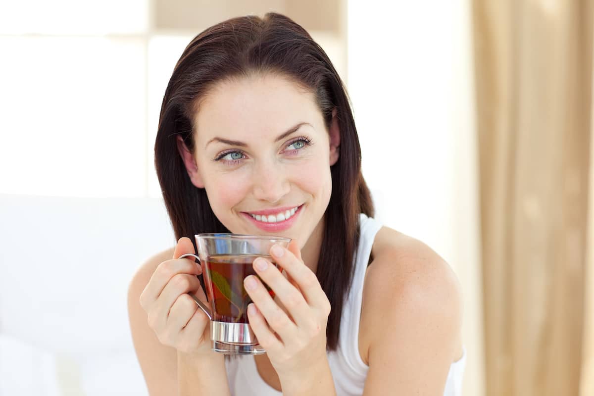 Frau mit dunklen Haaren trinkt einen Tee