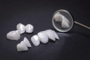 Veneers pros and cons: dental veneers on black background