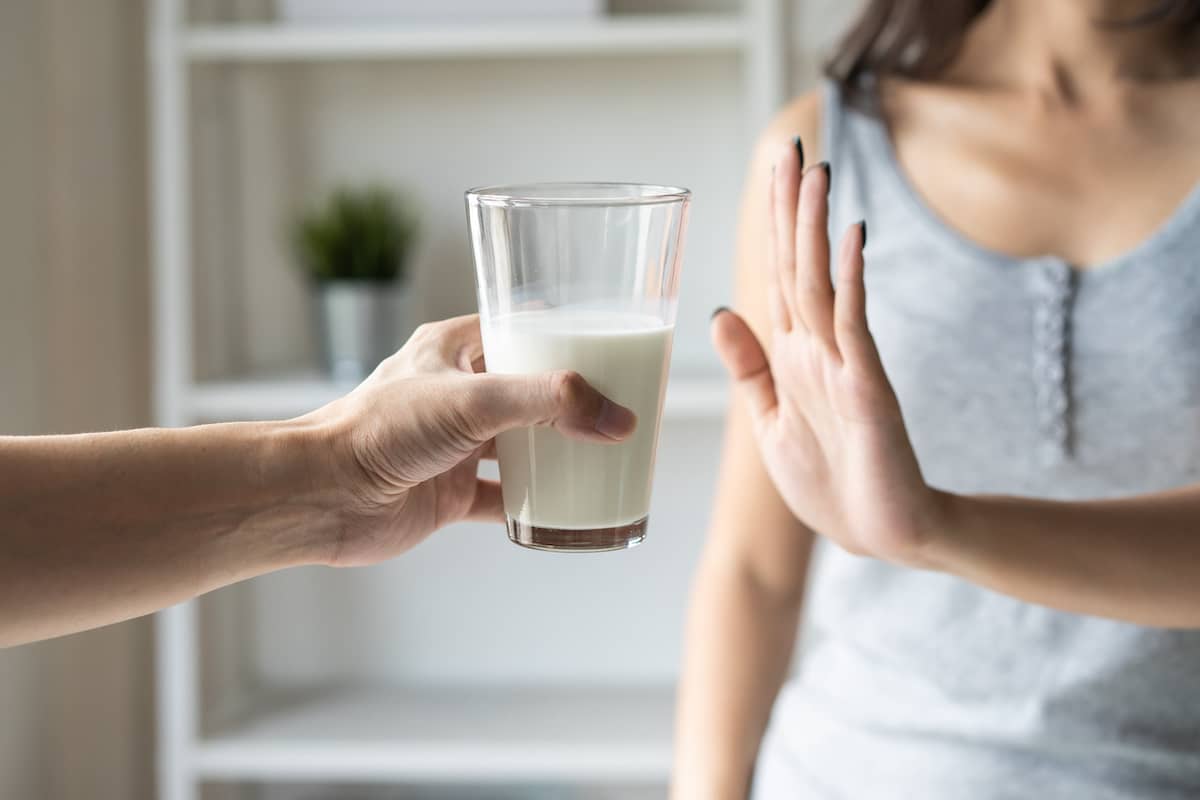 Frau sagt nein zu einem Glas Milch nach einer Zahnimplantat Behandlung