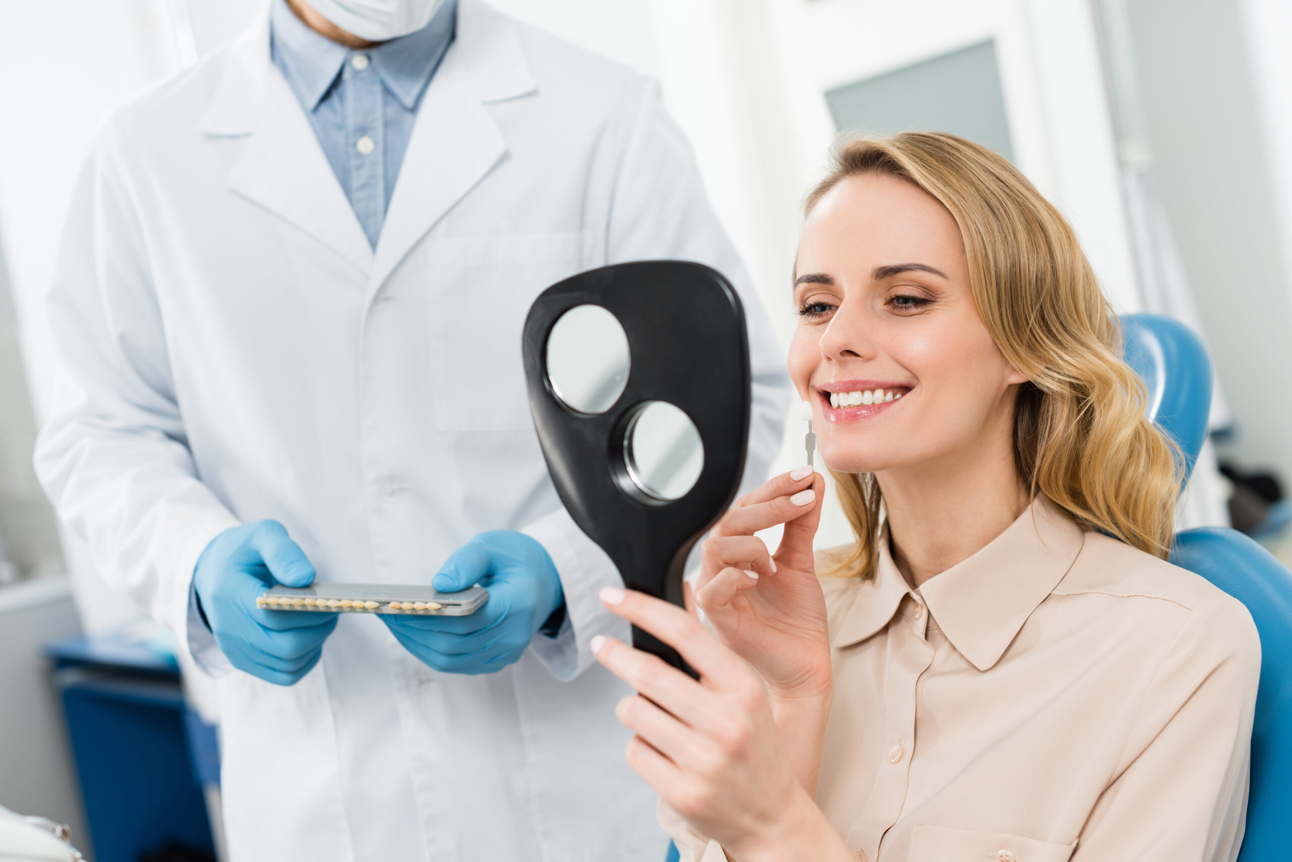Woman choosing dental implants abroad looking at mirror in modern dental clinic