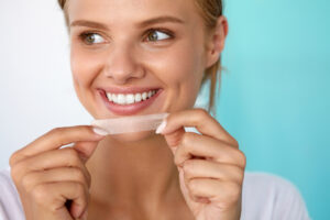 Frau mit Oral B Whitening Strips (Oral B Bleaching Streifen)