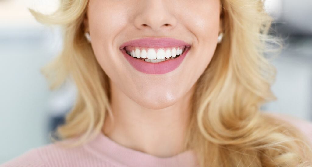 Unrecognizable blonde lady showing beautiful teeth after teeth filing