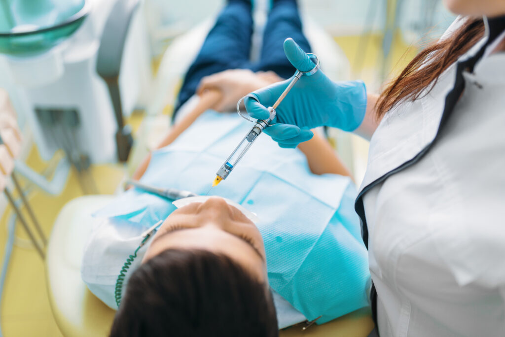 Un garçon dans le fauteuil du dentiste reçoit une anesthésie dentaire