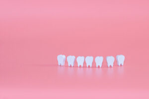 White types of teeth on a pink background