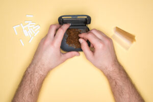 Man using tobacco box; tobacco use on yellow background