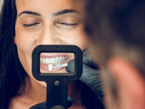 A dentist is adjusting dental veneers for a female patient; are veneers bad for your teeth
