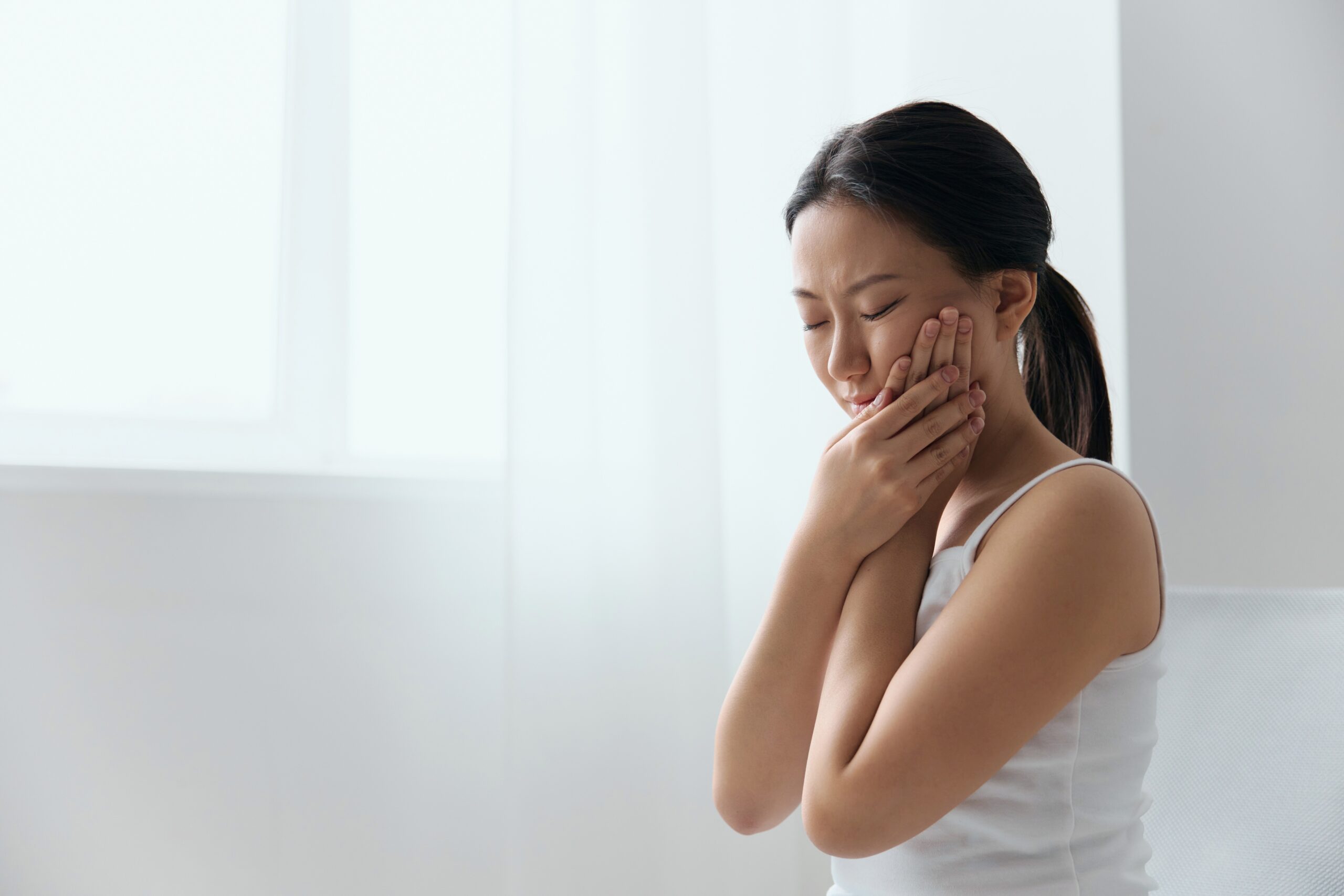 Können Weisheitszähne Probleme verursachen; junge Frau mit Zahnschmerzen