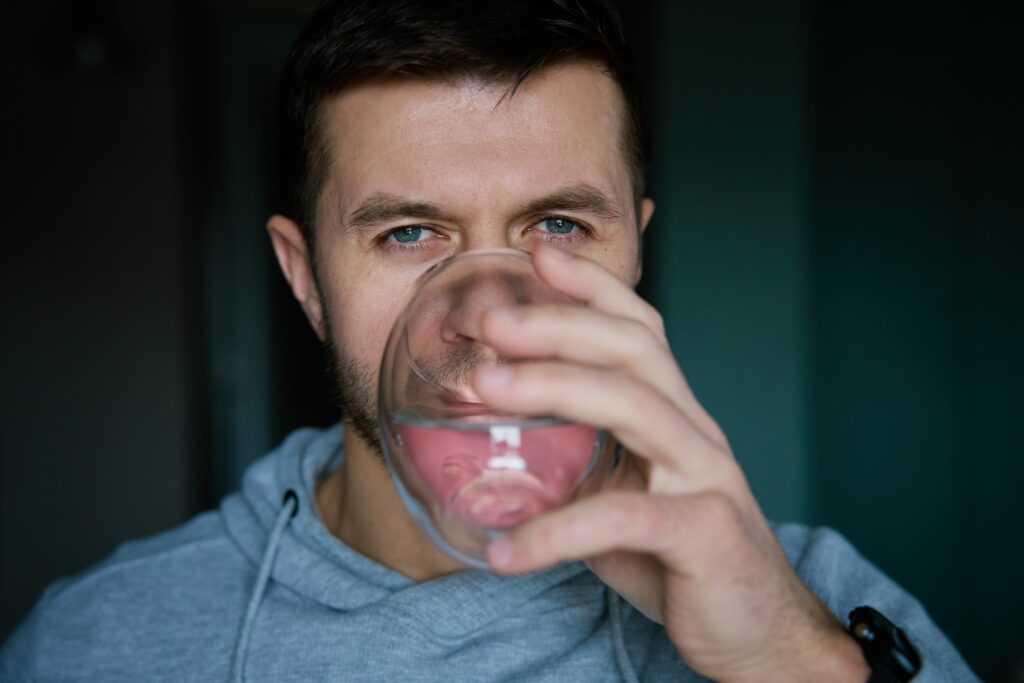 Man with a dry mouth drinks a glass of water